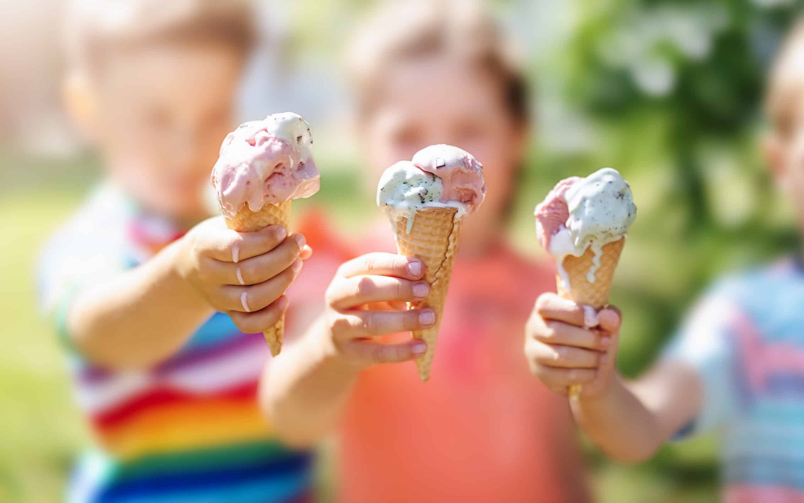 Group of children in the park eating cold ice cream.