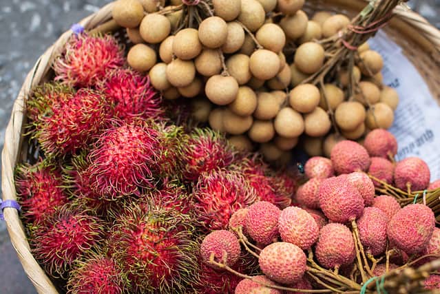 Basket with fresh exotic fruits of rambutan, lychee and longan on Asian market