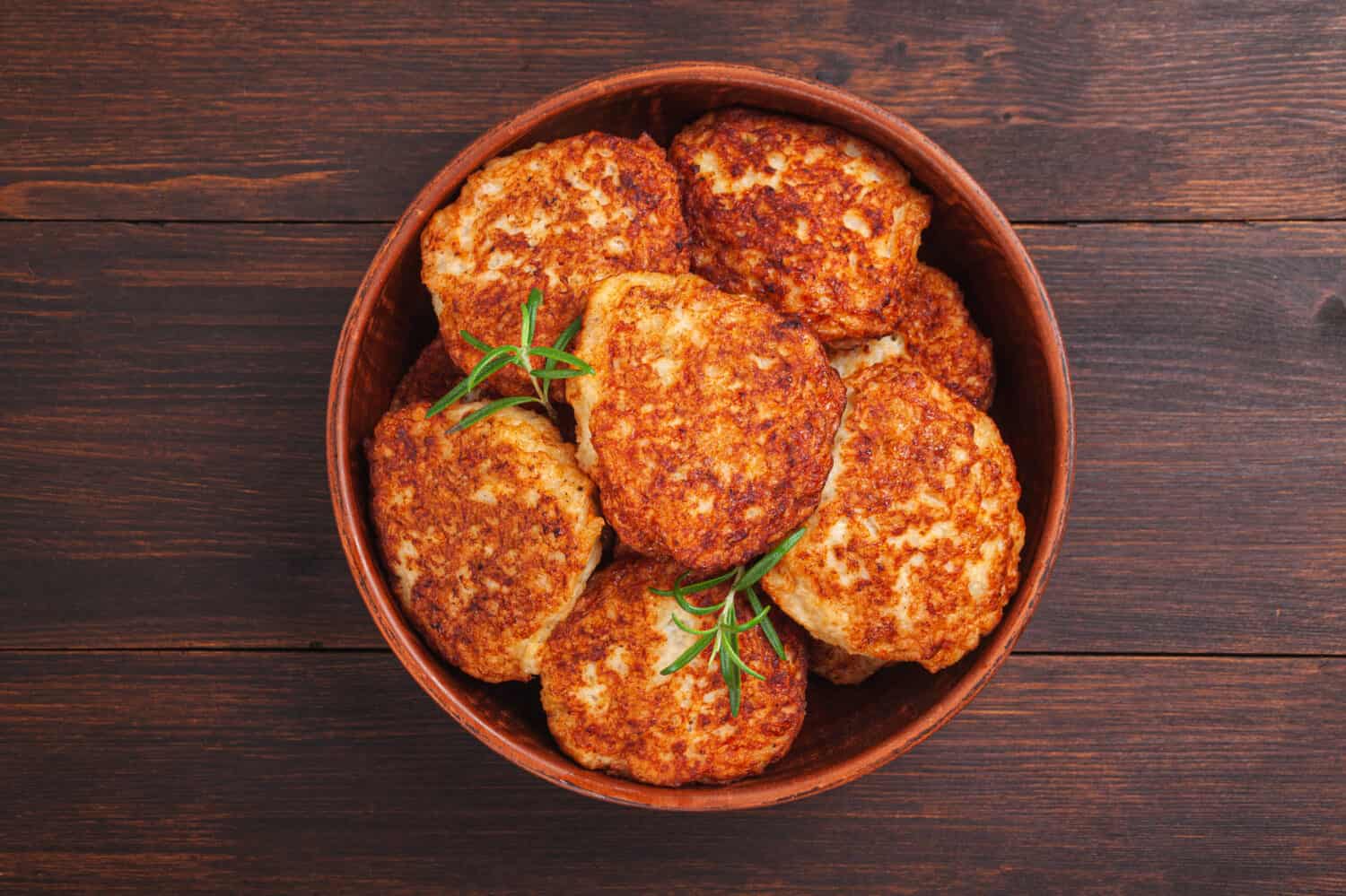 Juicy meat cutlets (beef, pork, chicken) in table on black background. Top view