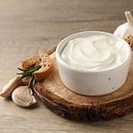 Garlic sauce, ingredients and snack on wooden background