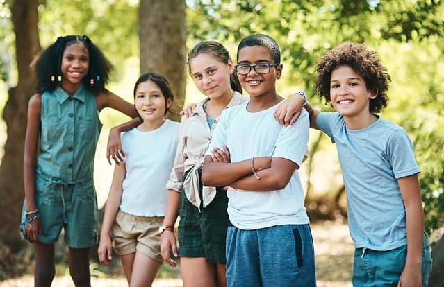 Keep nature close and your friends closer. Shot of a group of teenagers having fun at summer camp.