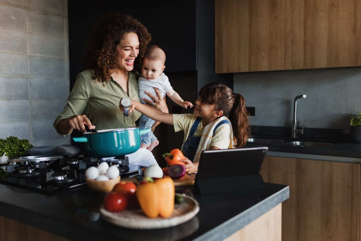 Hispanic mother and child daughter cooking at kitchen in Mexico Latin America