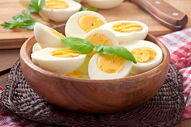 Boiled eggs in a bowl decorated with parsley leaves