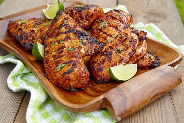 Grilled chicken breast served with herbs and lime