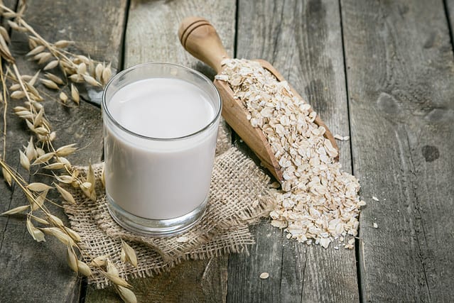 Oat milk alternative on rustic wood background, copy space