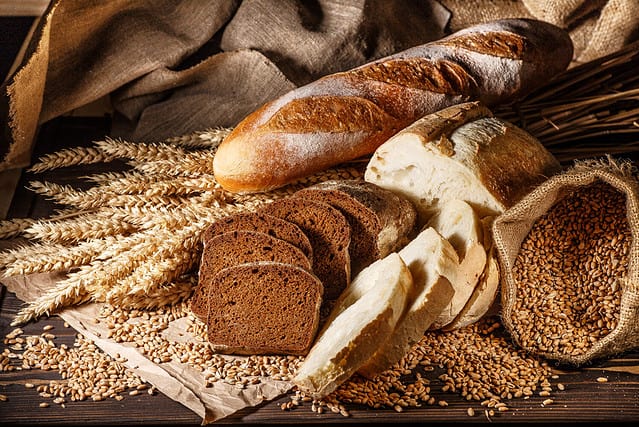 Assortment of baked bread on wooden table background